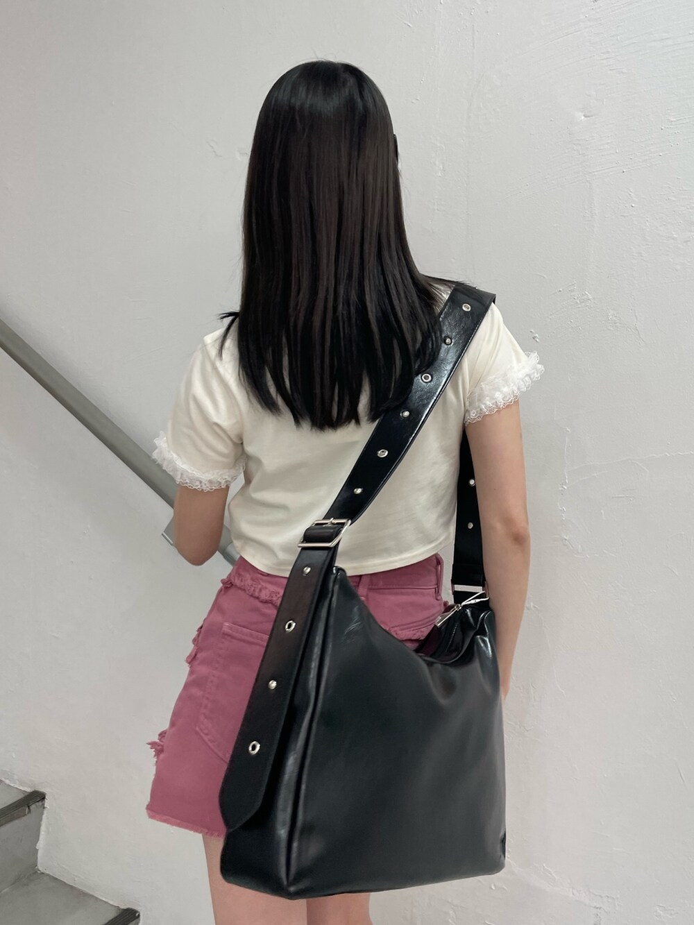 ピンク系のスカート、ホワイト系のTシャツ/カットソー、ブラック系のショルダーバッグを着用したレディースの春コーディネートの7枚目の写真