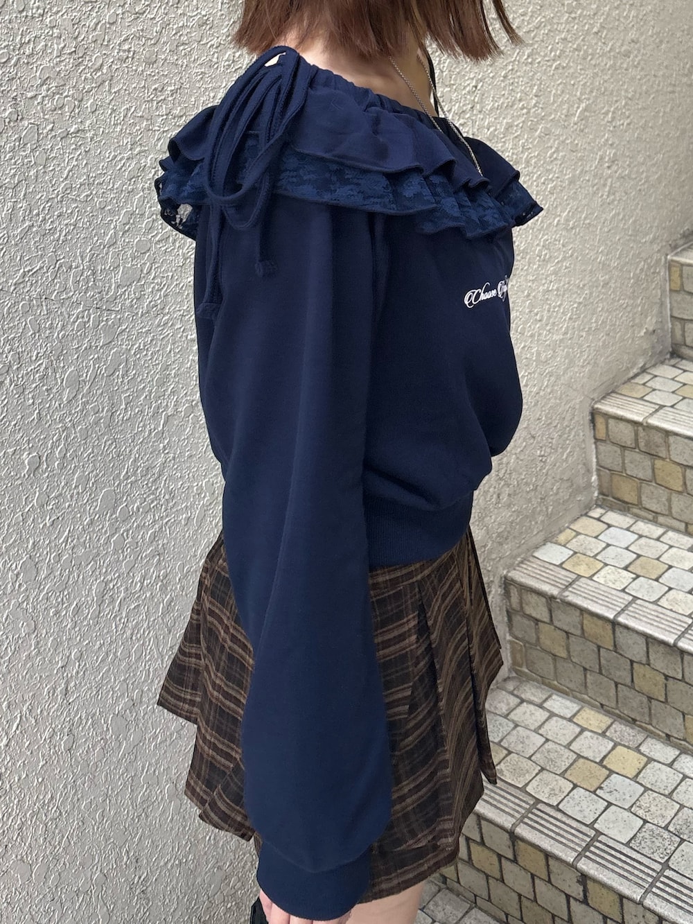 グレー系のスウェット、ブルー系のスカート、ブラック系のブーツを着用したレディースの冬コーディネートの6枚目の写真