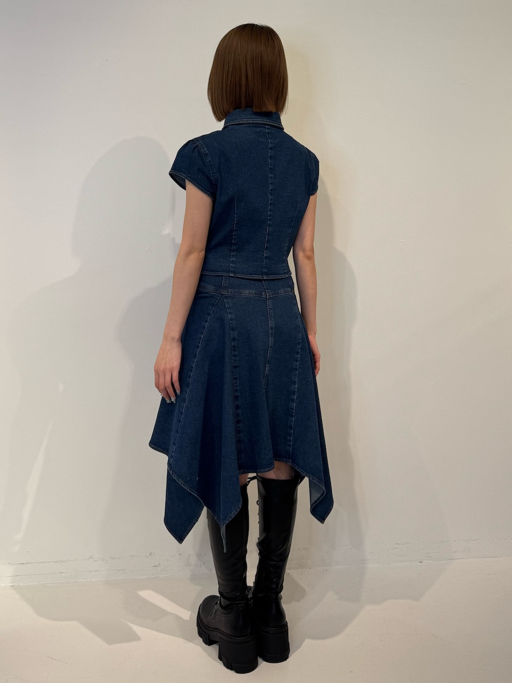 ブルー系のシャツ/ブラウス、ブルー系のスカート、ブラック系のブーツを着用したレディースの春コーディネートの4枚目の写真