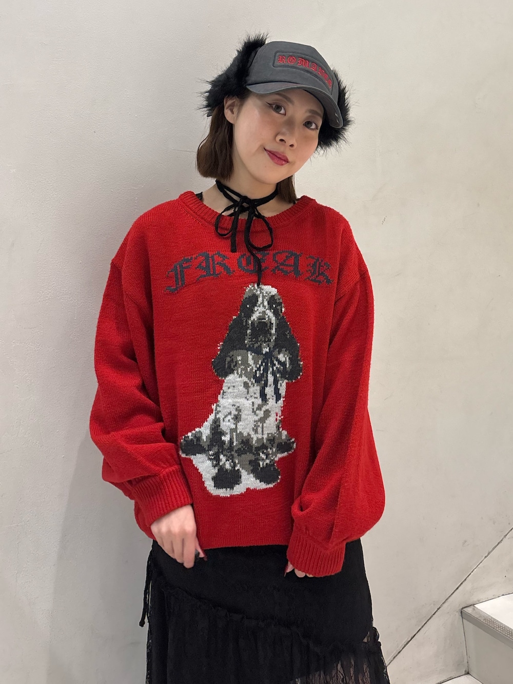 レッド系のニット/セーター、ブラック系のワンピース、ブラック系のブーツを着用したレディースの冬コーディネートの6枚目の写真