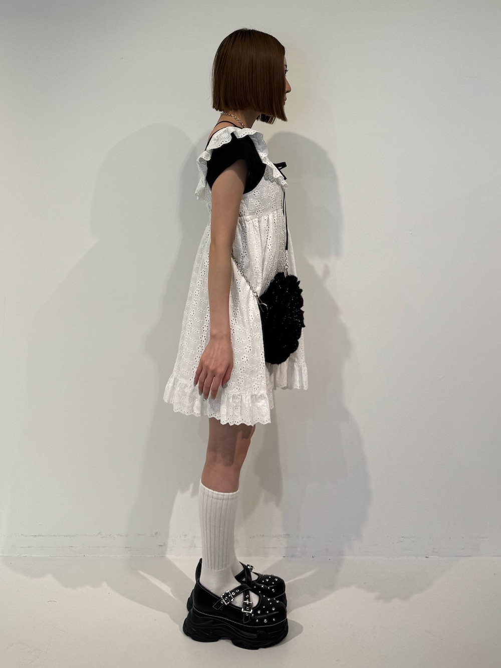 ホワイト系のワンピース、ブラック系のショルダーバッグ、ブラック系のTシャツ/カットソーを着用したレディースの春コーディネートの3枚目の写真