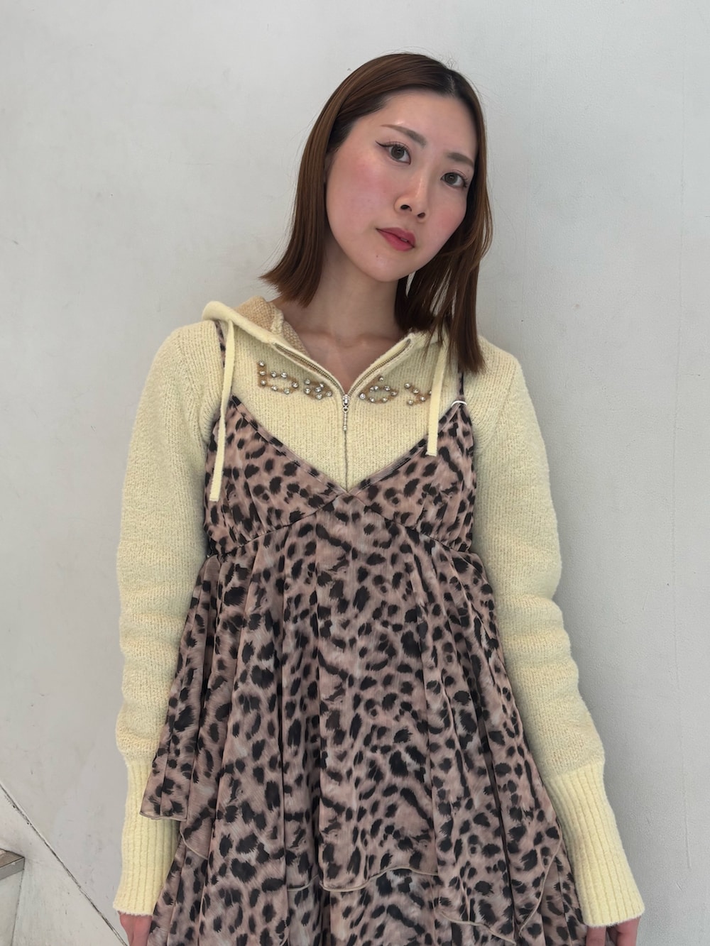 ブラウン系のワンピース、イエロー系のパーカー、ブラック系のブーツを着用したレディースの冬コーディネートの5枚目の写真