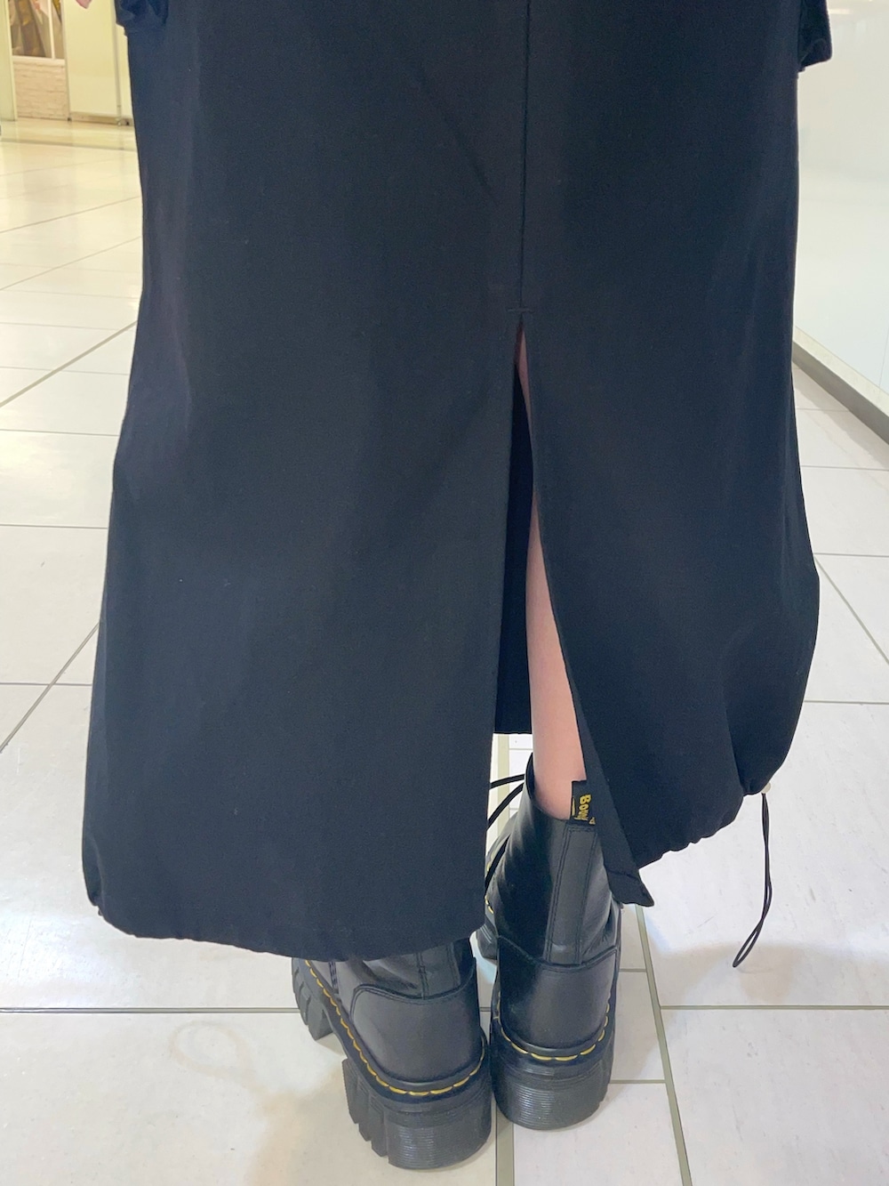 ブラック系のスカート、ブラック系のベスト、レッド系のシャツ/ブラウスを着用したレディースの春コーディネートの10枚目の写真