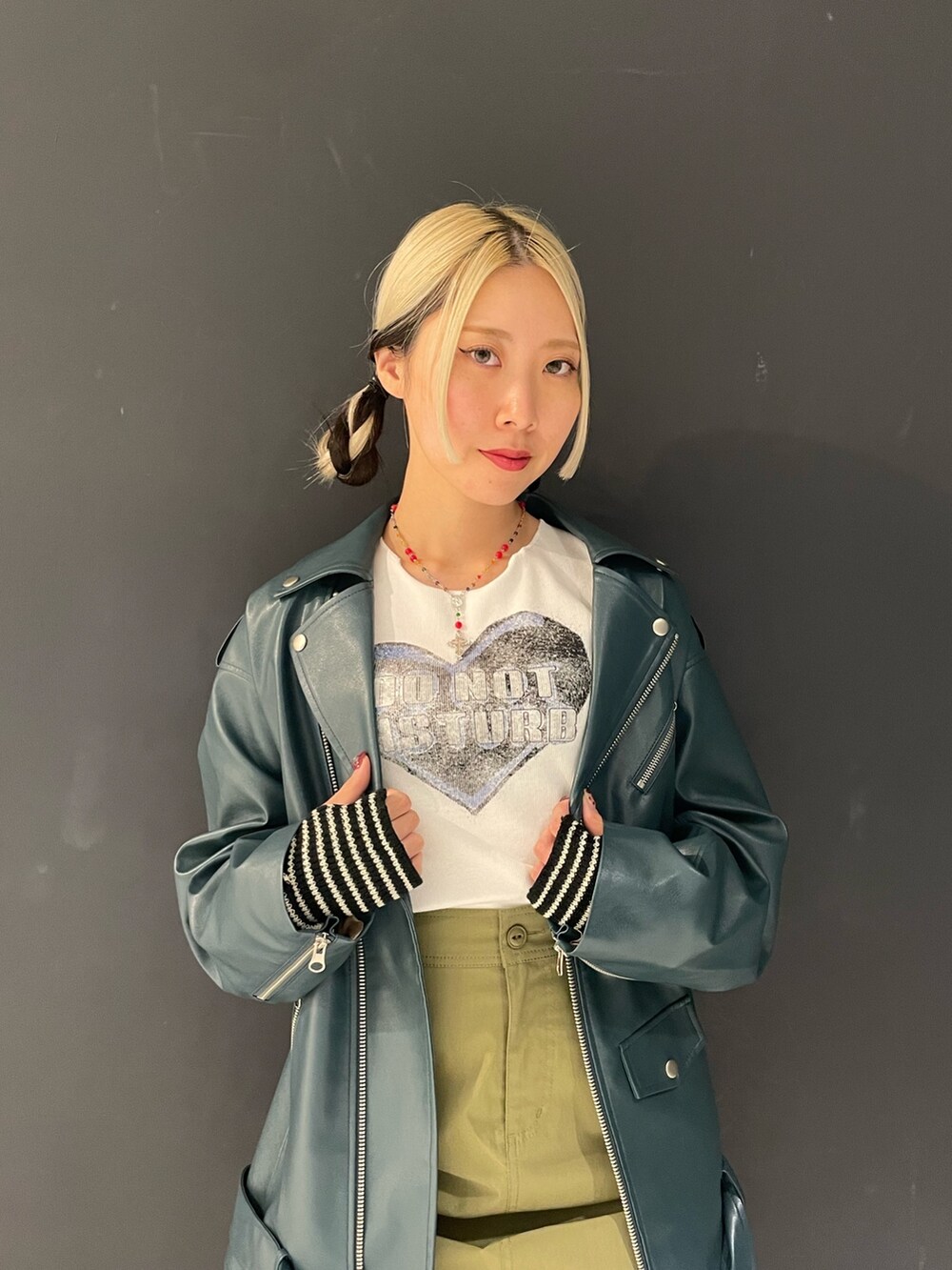 ホワイト系のTシャツ/カットソー、グリーン系のスカート、ブルー系のライダースジャケットを着用したレディースの秋コーディネートの5枚目の写真