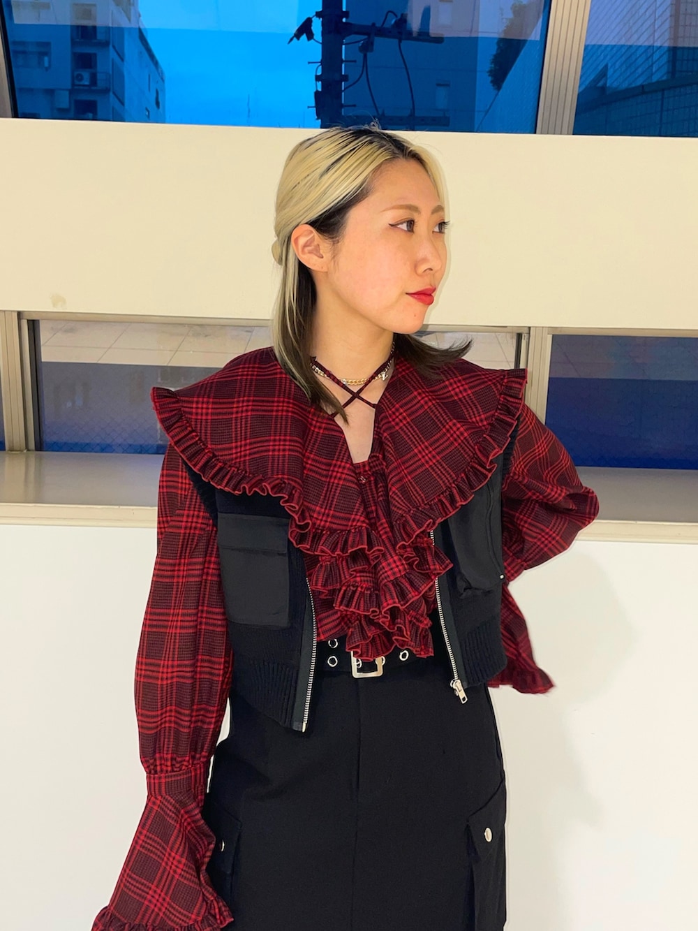 ブラック系のスカート、ブラック系のベスト、レッド系のシャツ/ブラウスを着用したレディースの春コーディネートの5枚目の写真