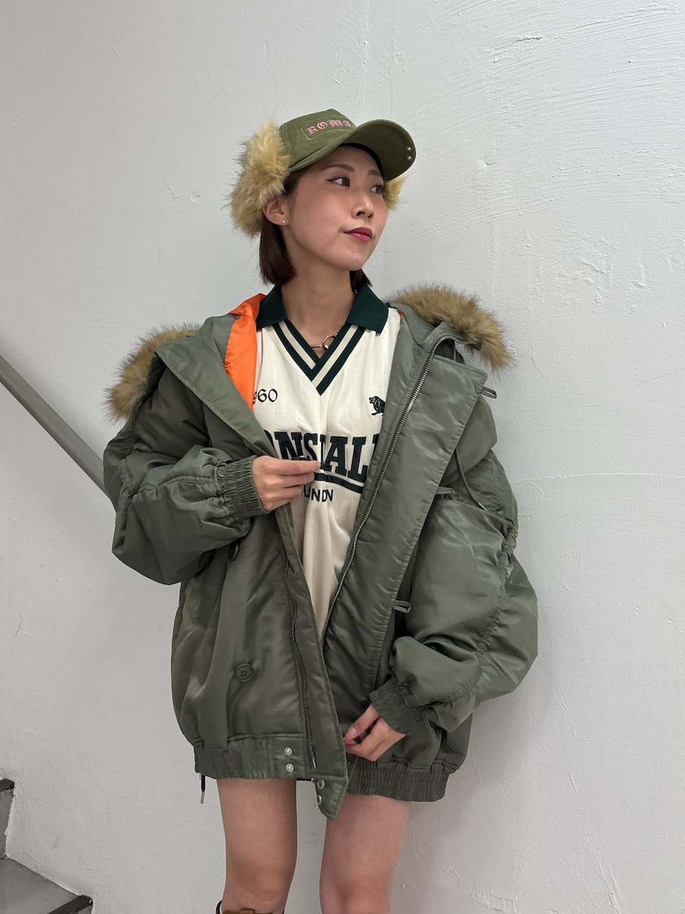 ホワイト系のTシャツ/カットソー、ホワイト系のスカート、グリーン系のブルゾンを着用したレディースの秋コーディネートの8枚目の写真