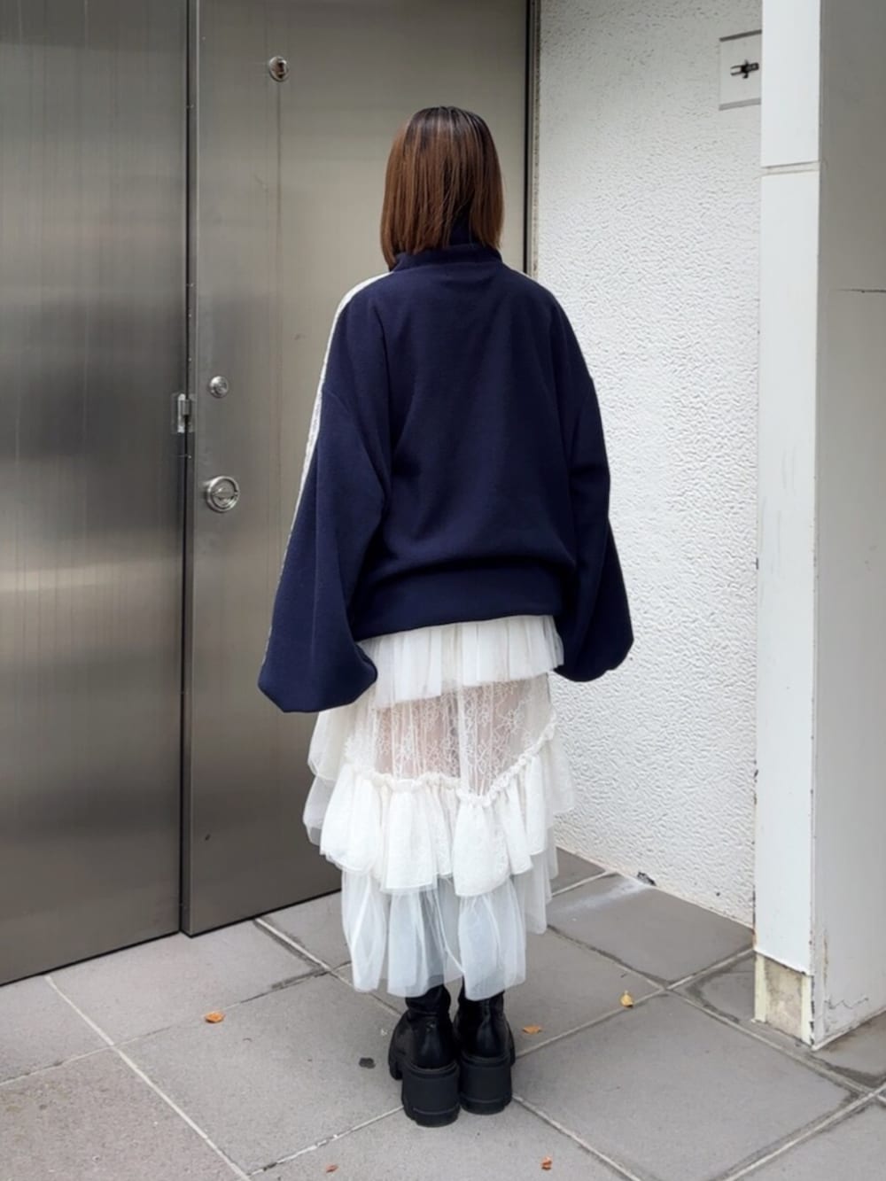 ブラック系のブーツ、ブルー系のTシャツ/カットソー、ホワイト系のスカートを着用したレディースの秋コーディネートの4枚目の写真