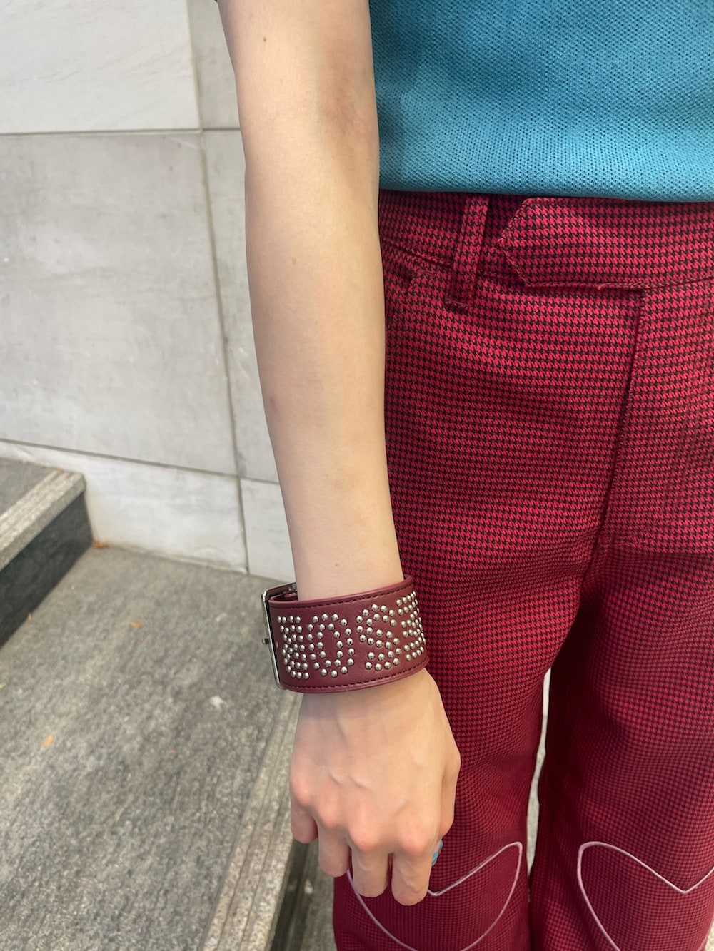 ブルー系のニット/セーター、レッド系のその他パンツ、レッド系のブレスレットを着用したレディースの夏コーディネートの7枚目の写真