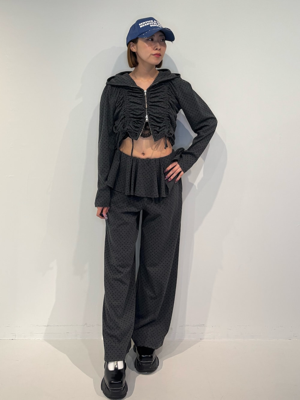 グレー系のスウェットパンツ、ブラック系のパーカー、ブラック系のローファーを着用したレディースの冬コーディネートの2枚目の写真