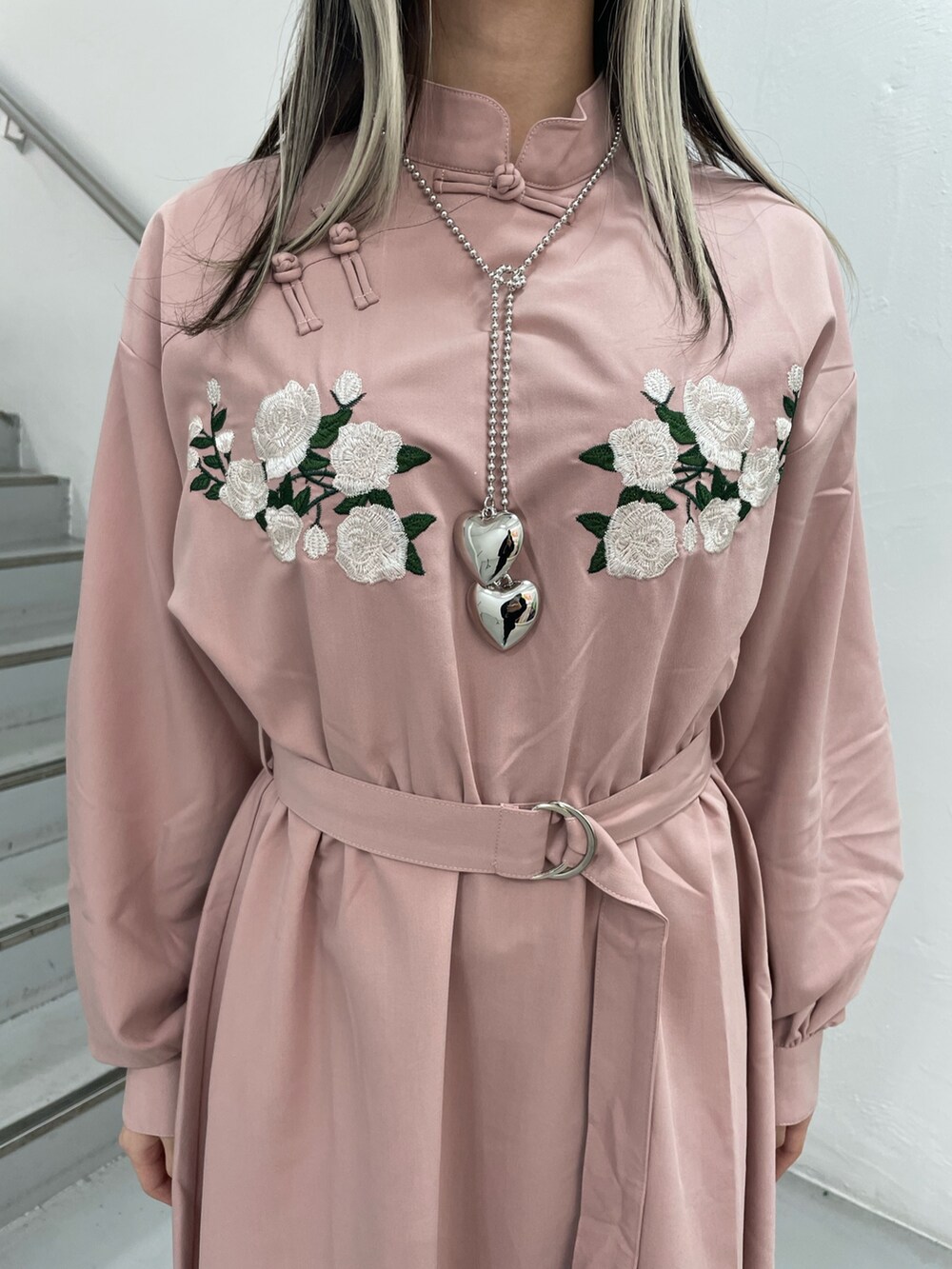 ピンク系のワンピース、シルバー系のネックレスを着用したレディースの冬コーディネートの8枚目の写真