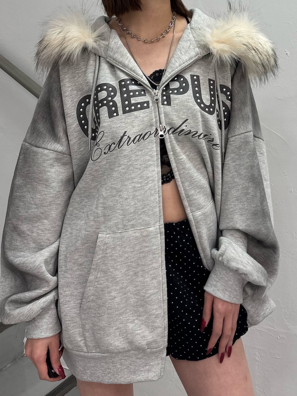 ブラック系のスカート、グレー系のパーカー、ブラック系のブーツを着用したレディースの冬コーディネートの8枚目の写真