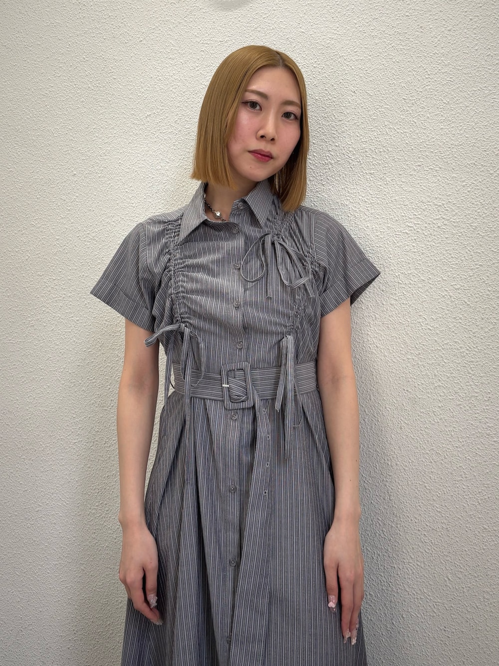 グレー系のワンピース、ブラック系のサンダル、シルバー系のネックレスを着用したレディースの春コーディネートの6枚目の写真