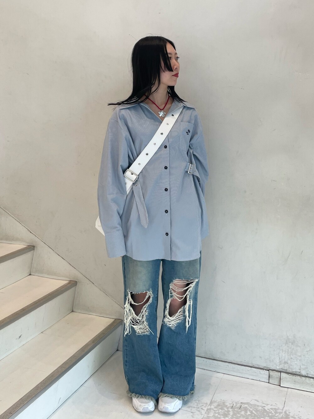 ブルー系のシャツ/ブラウス、シルバー系のショルダーバッグ、ブルー系のデニムパンツを着用したレディースの春コーディネートの2枚目の写真