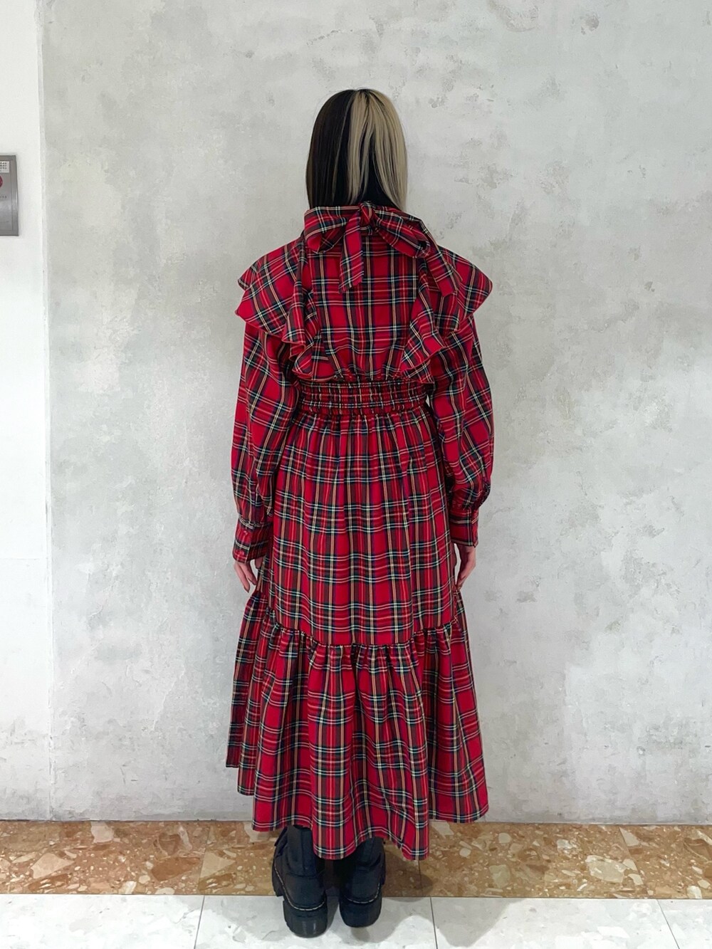 レッド系のワンピース、ゴールド系のネックレスを着用したレディースの冬コーディネートの3枚目の写真