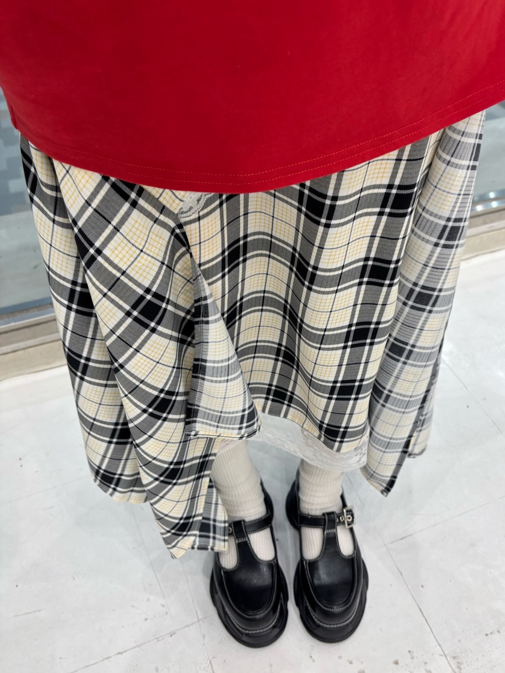 レッド系のTシャツ/カットソー、ホワイト系のスカート、ブラック系のボストンバッグを着用したレディースの春コーディネートの9枚目の写真