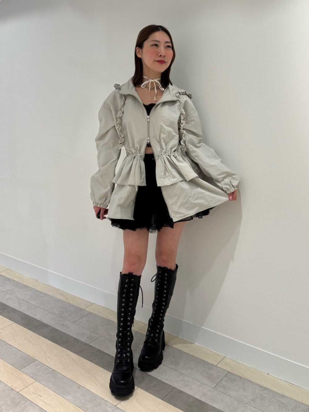 ブラウン系のブーツ、レッド系のスカート、ホワイト系のナイロンジャケットを着用したレディースの冬コーディネートの3枚目の写真