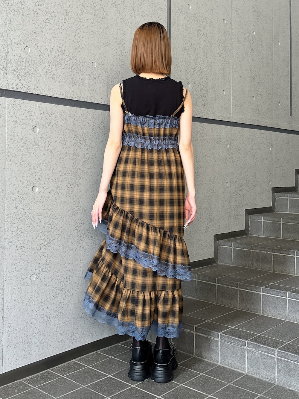 イエロー系のワンピース、ブラック系のサンダル、ブラック系のタンクトップを着用したレディースの夏コーディネートの4枚目の写真