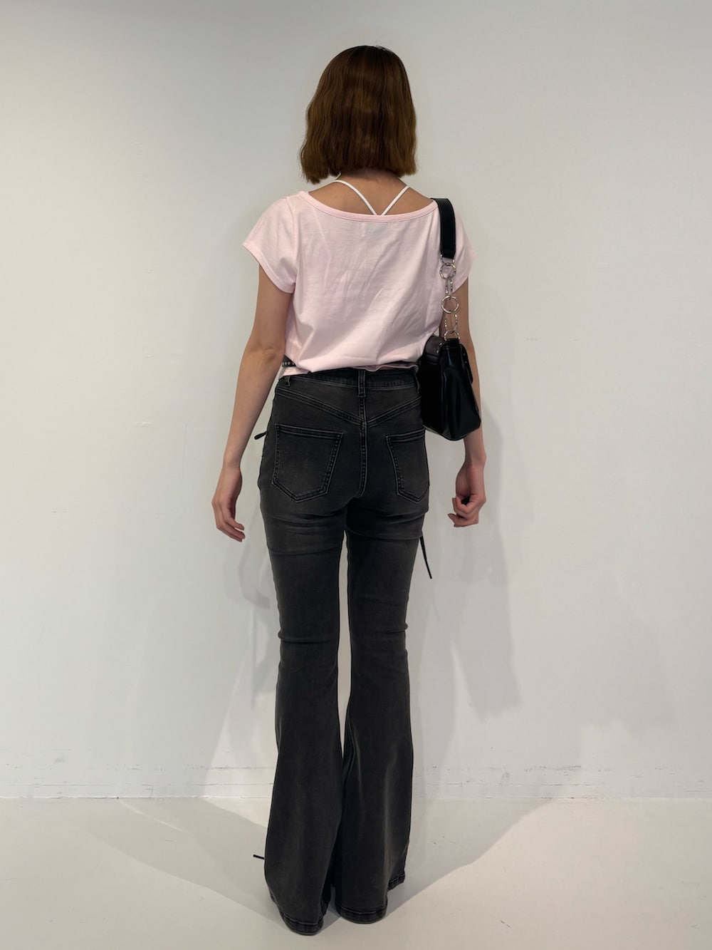 ブラック系のデニムパンツ、ブラック系のパンプス、ブラック系のハンドバッグを着用したレディースの春コーディネートの4枚目の写真