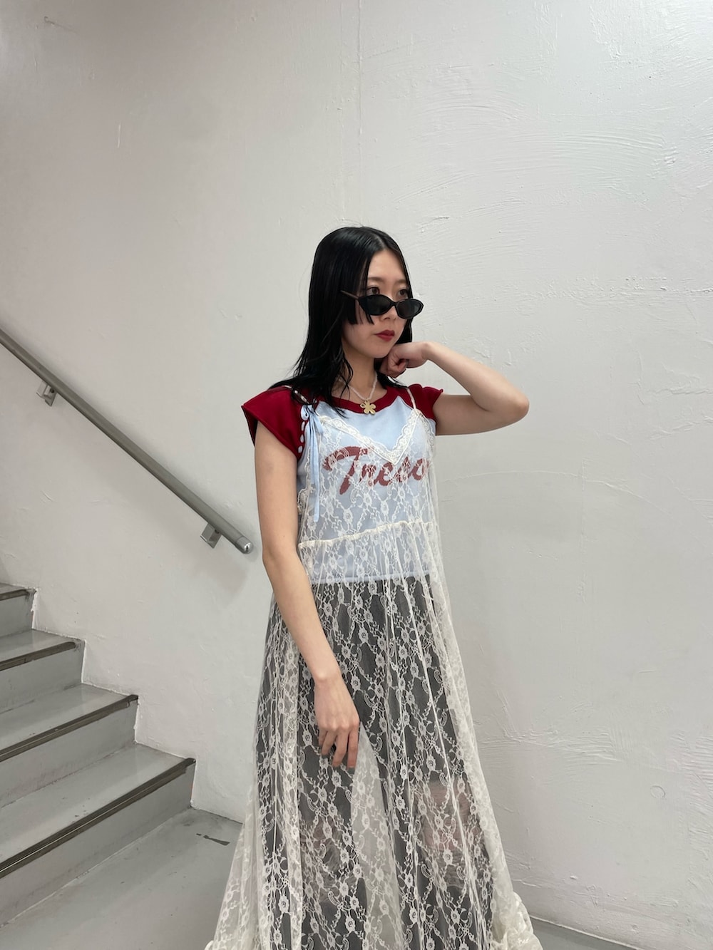 ブルー系のニット/セーター、ホワイト系のワンピース、ブラック系のデニムパンツを着用したレディースの春コーディネートの7枚目の写真