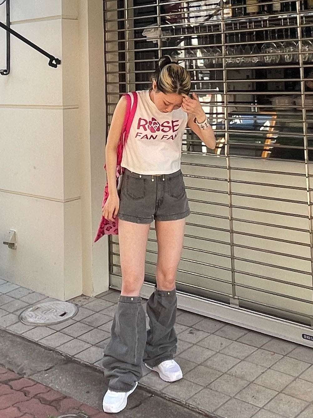 ホワイト系のタンクトップ、ブラック系のデニムパンツ、ピンク系のトートバッグを着用したレディースの春コーディネートの2枚目の写真