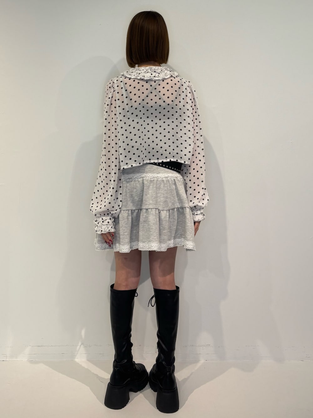 ホワイト系のシャツ/ブラウス、グレー系のワンピース、ブラック系のブーツを着用したレディースの冬コーディネートの4枚目の写真