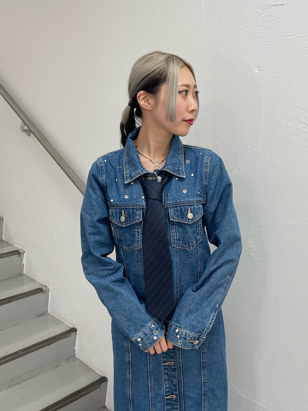 ブルー系のワンピース、ブラック系のブーツ、ブルー系のネクタイを着用したレディースの冬コーディネートの6枚目の写真