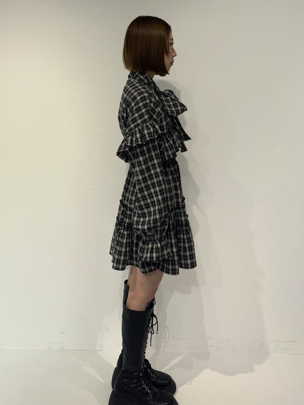 ブラック系のワンピース、ブラック系のトートバッグ、ブラック系のブーツを着用したレディースの冬コーディネートの3枚目の写真