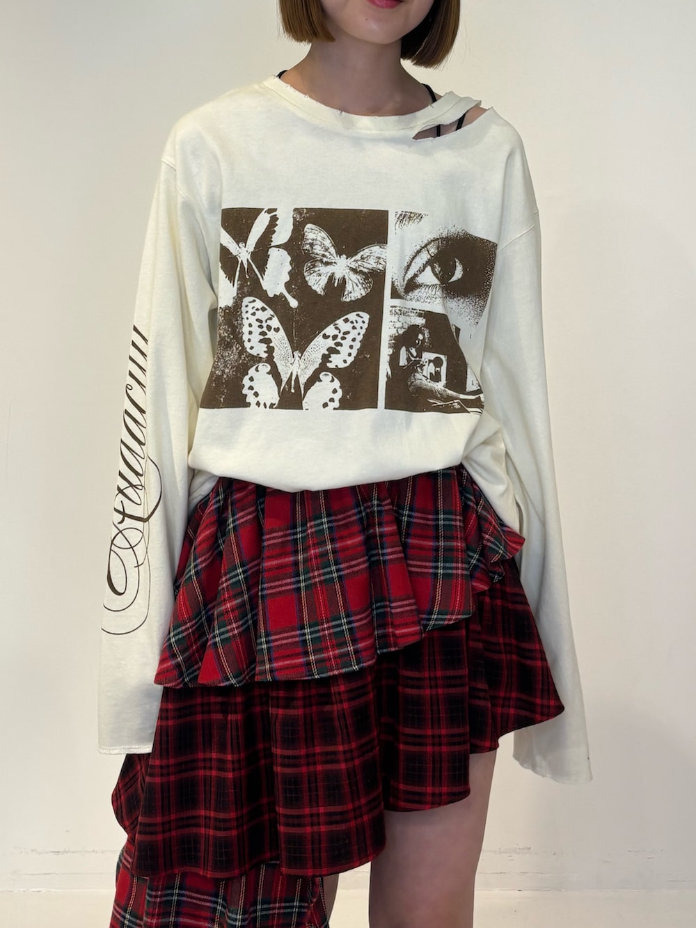 ブラック系のブーツ、ホワイト系のTシャツ/カットソー、レッド系のスカートを着用したレディースの冬コーディネートの6枚目の写真