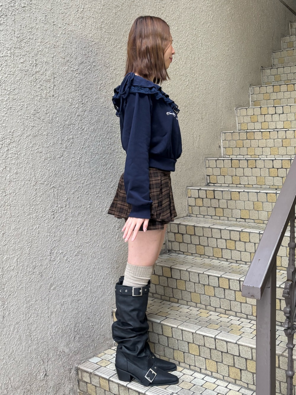 グレー系のスウェット、ブルー系のスカート、ブラック系のブーツを着用したレディースの冬コーディネートの3枚目の写真