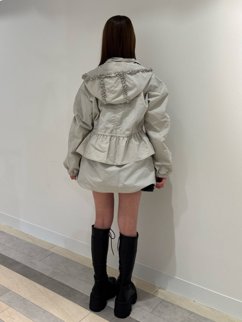 ブラウン系のブーツ、レッド系のスカート、ホワイト系のナイロンジャケットを着用したレディースの冬コーディネートの5枚目の写真