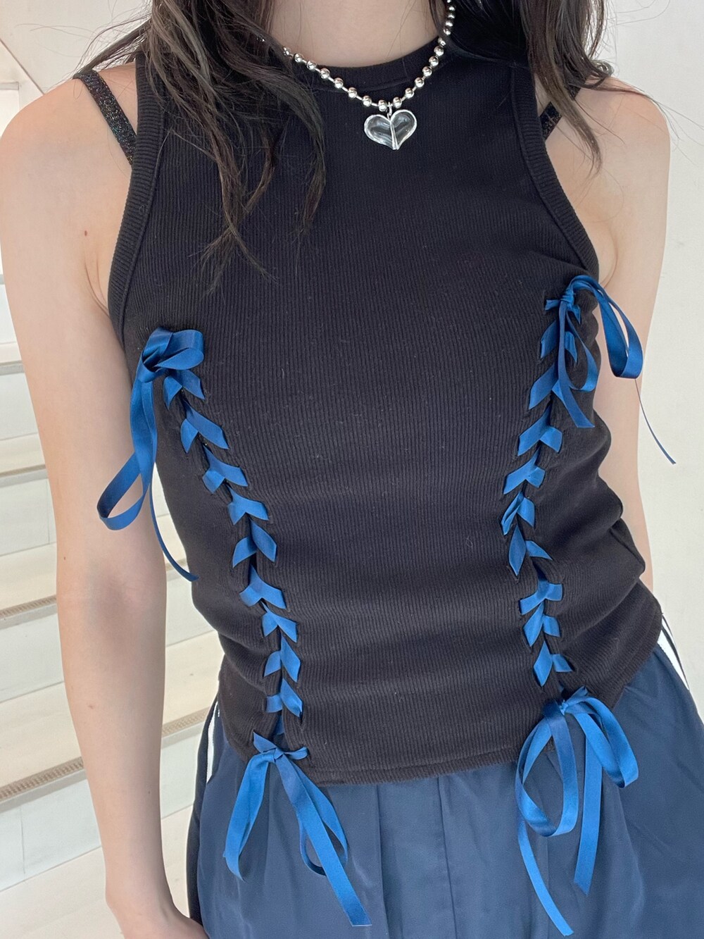 ブルー系のスカート、ブラック系のタンクトップ、ブラック系のキャミソールを着用したレディースの夏コーディネートの8枚目の写真