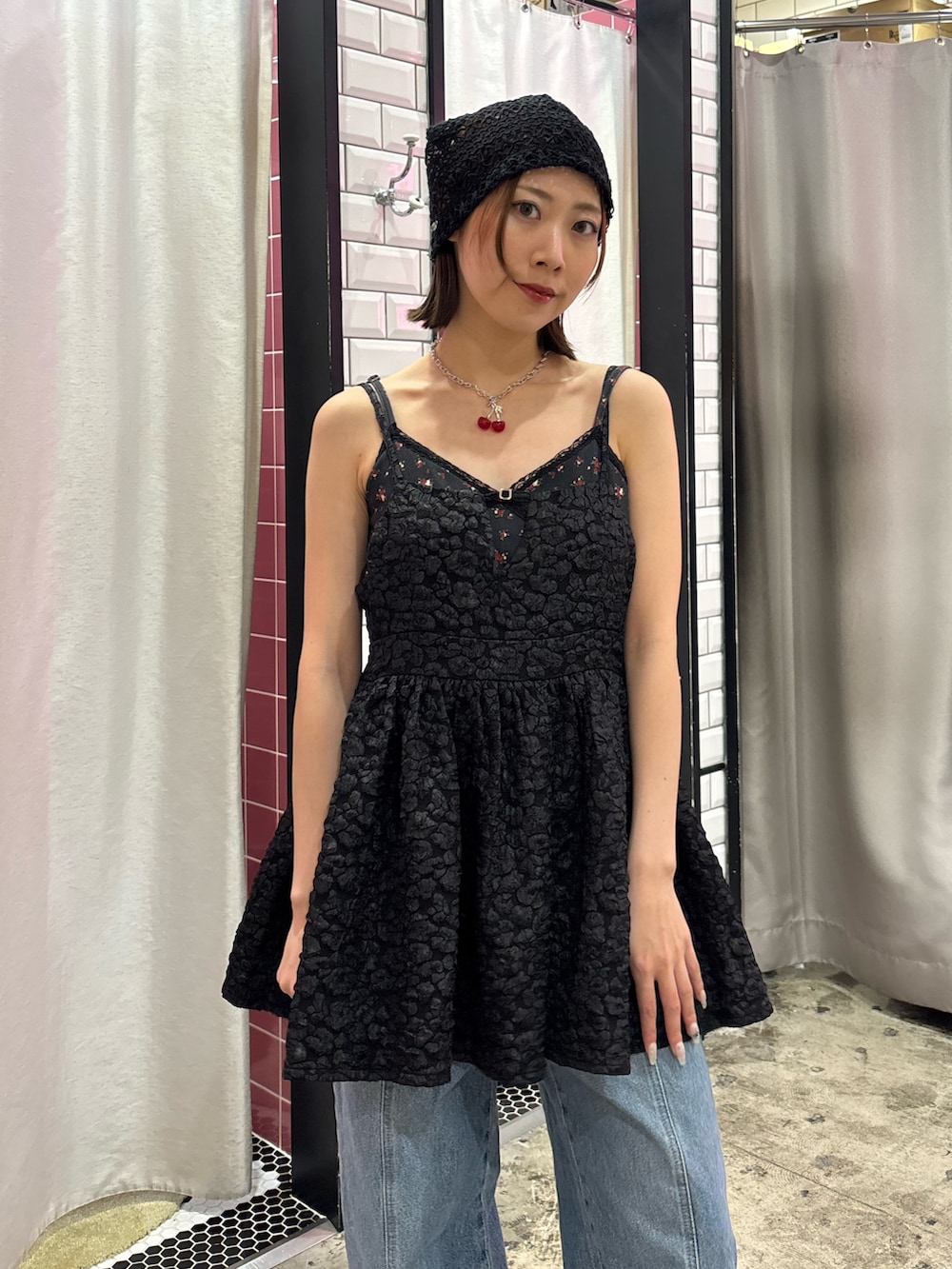 ブルー系のデニムパンツ、ブラック系のチュニック、レッド系のネックレスを着用したレディースの夏コーディネートの5枚目の写真