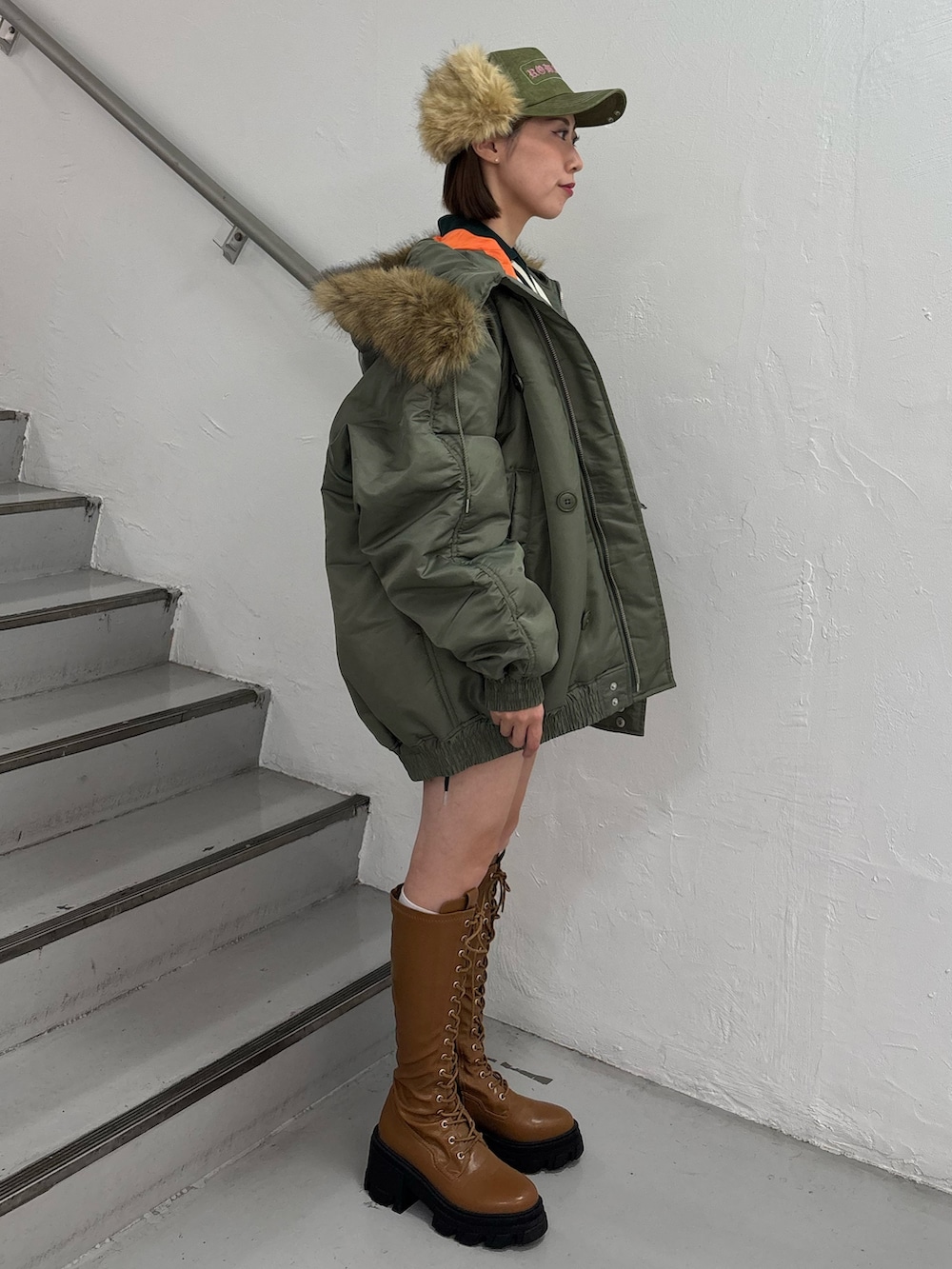 ホワイト系のTシャツ/カットソー、ホワイト系のスカート、グリーン系のブルゾンを着用したレディースの秋コーディネートの4枚目の写真