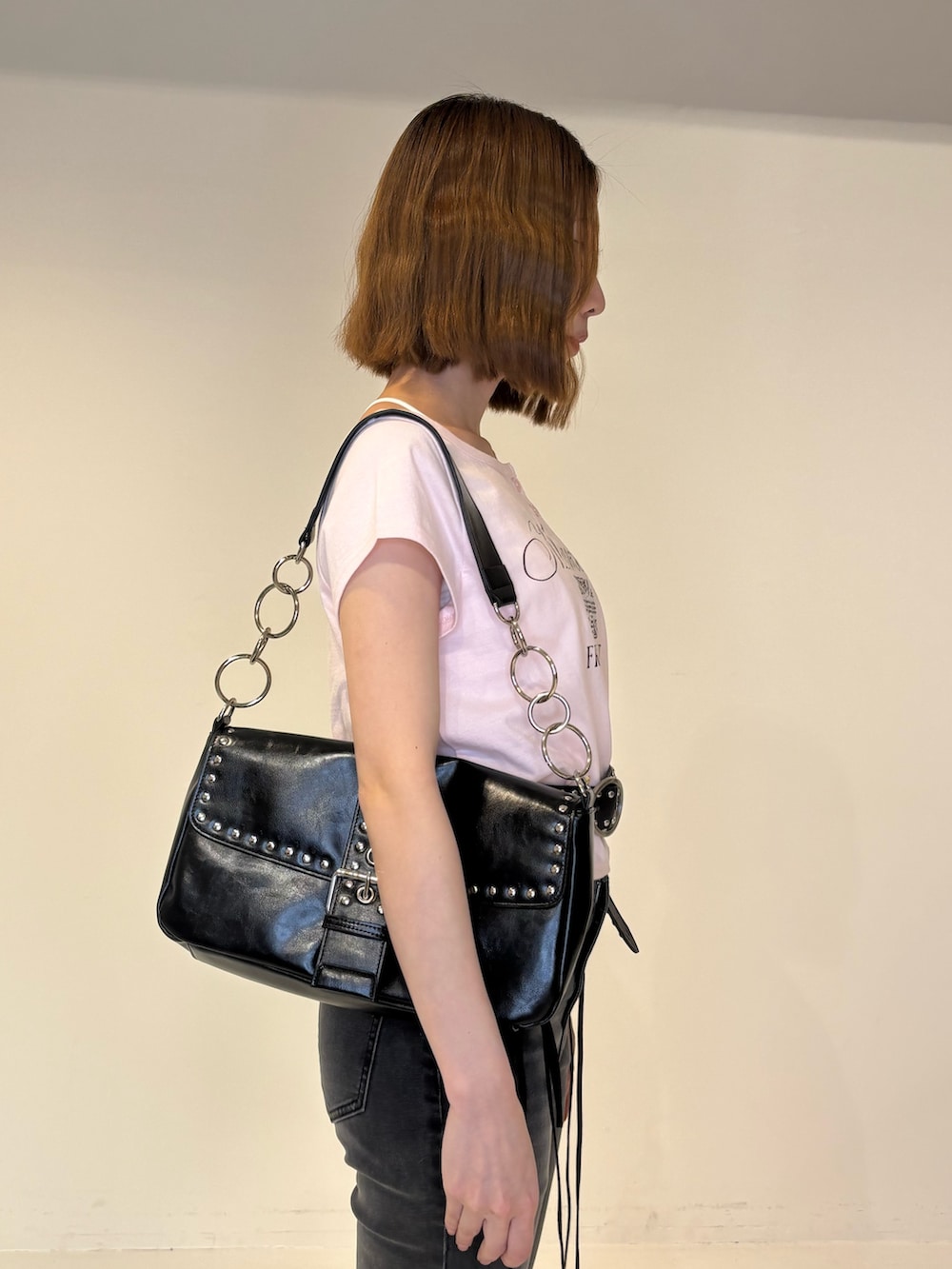 ブラック系のデニムパンツ、ブラック系のパンプス、ブラック系のハンドバッグを着用したレディースの春コーディネートの6枚目の写真