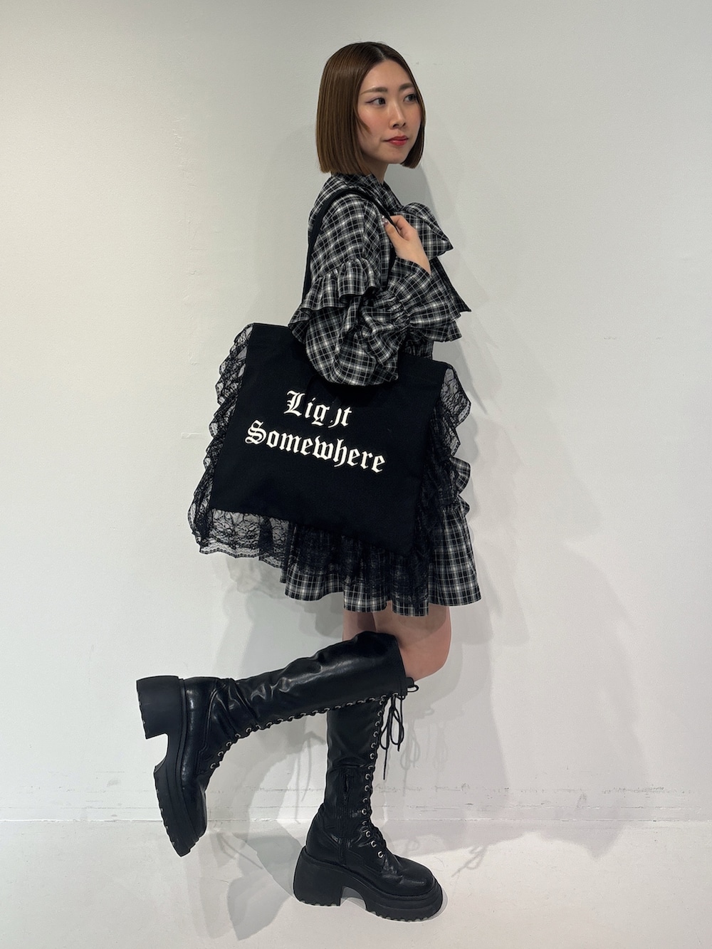 ブラック系のワンピース、ブラック系のトートバッグ、ブラック系のブーツを着用したレディースの冬コーディネートの5枚目の写真