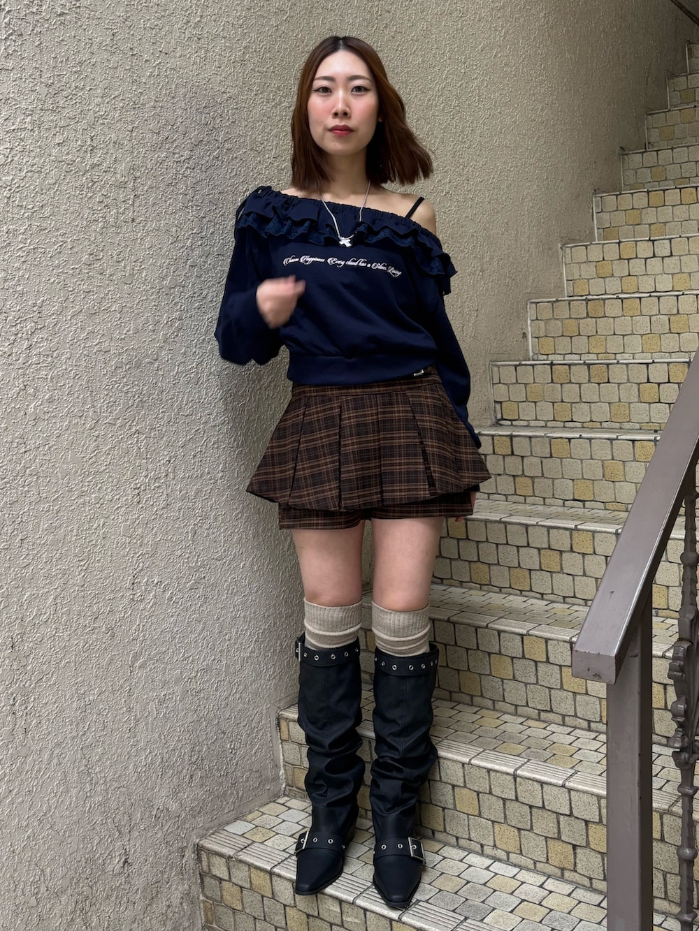 グレー系のスウェット、ブルー系のスカート、ブラック系のブーツを着用したレディースの冬コーディネートの2枚目の写真