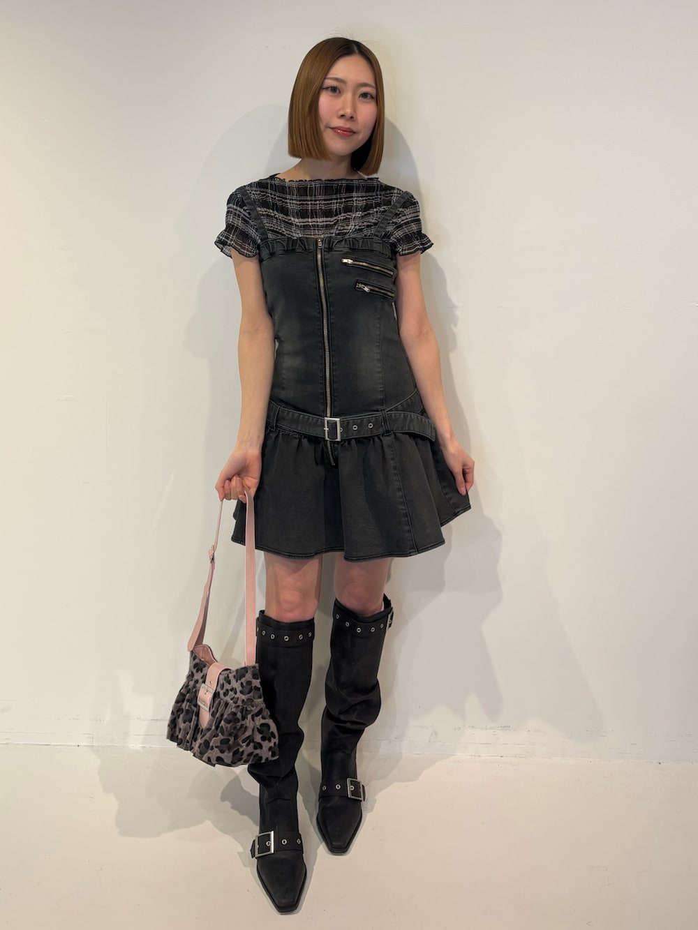 ブラック系のブーツ、ブラック系のワンピース、ブラック系のTシャツ/カットソーを着用したレディースの春コーディネートの2枚目の写真