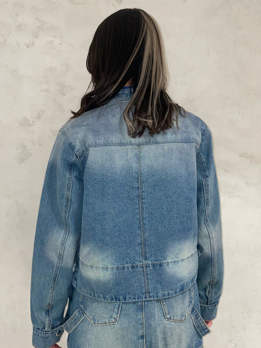 ブルー系のデニムスカート、ブルー系のニット/セーター、ブルー系のデニムジャケットを着用したレディースの冬コーディネートの6枚目の写真