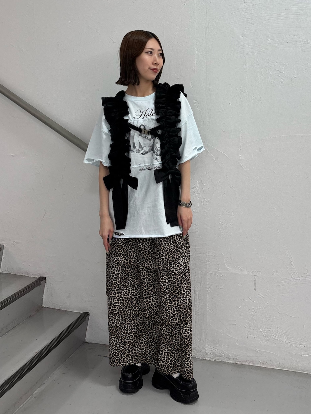 ブラウン系のスカート、ブルー系のTシャツ/カットソー、ブラック系のスニーカーを着用したレディースの夏コーディネートの2枚目の写真