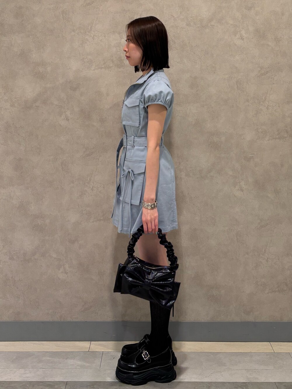 ブルー系のワンピース、ブラック系のハンドバッグ、ブラック系のローファーを着用したレディースの春コーディネートの3枚目の写真