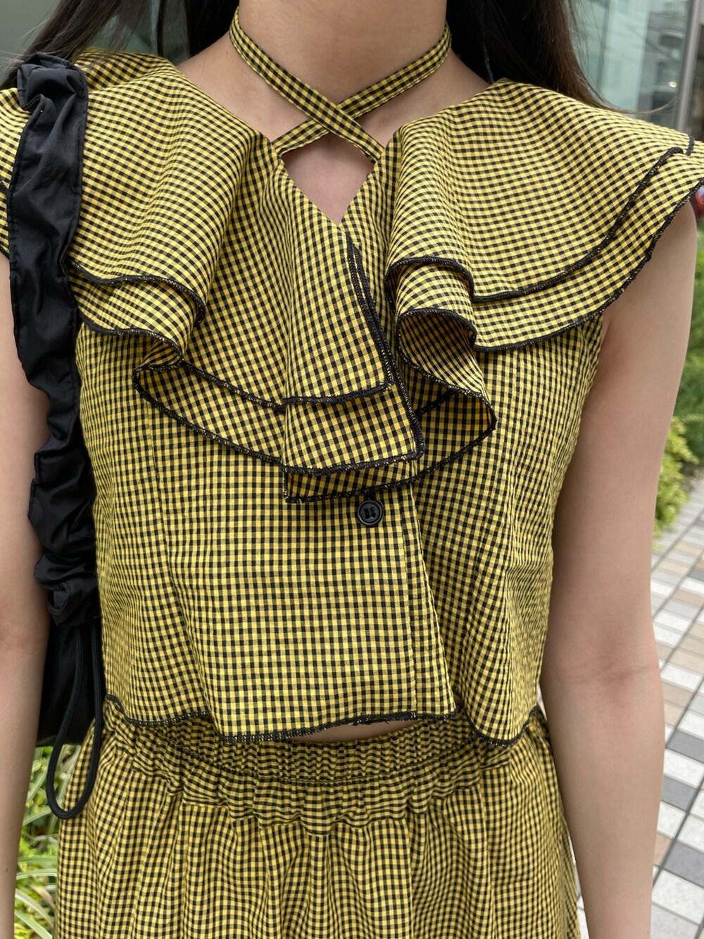 イエロー系のスカート、イエロー系のシャツ/ブラウス、ブラック系のショルダーバッグを着用したレディースの夏コーディネートの6枚目の写真