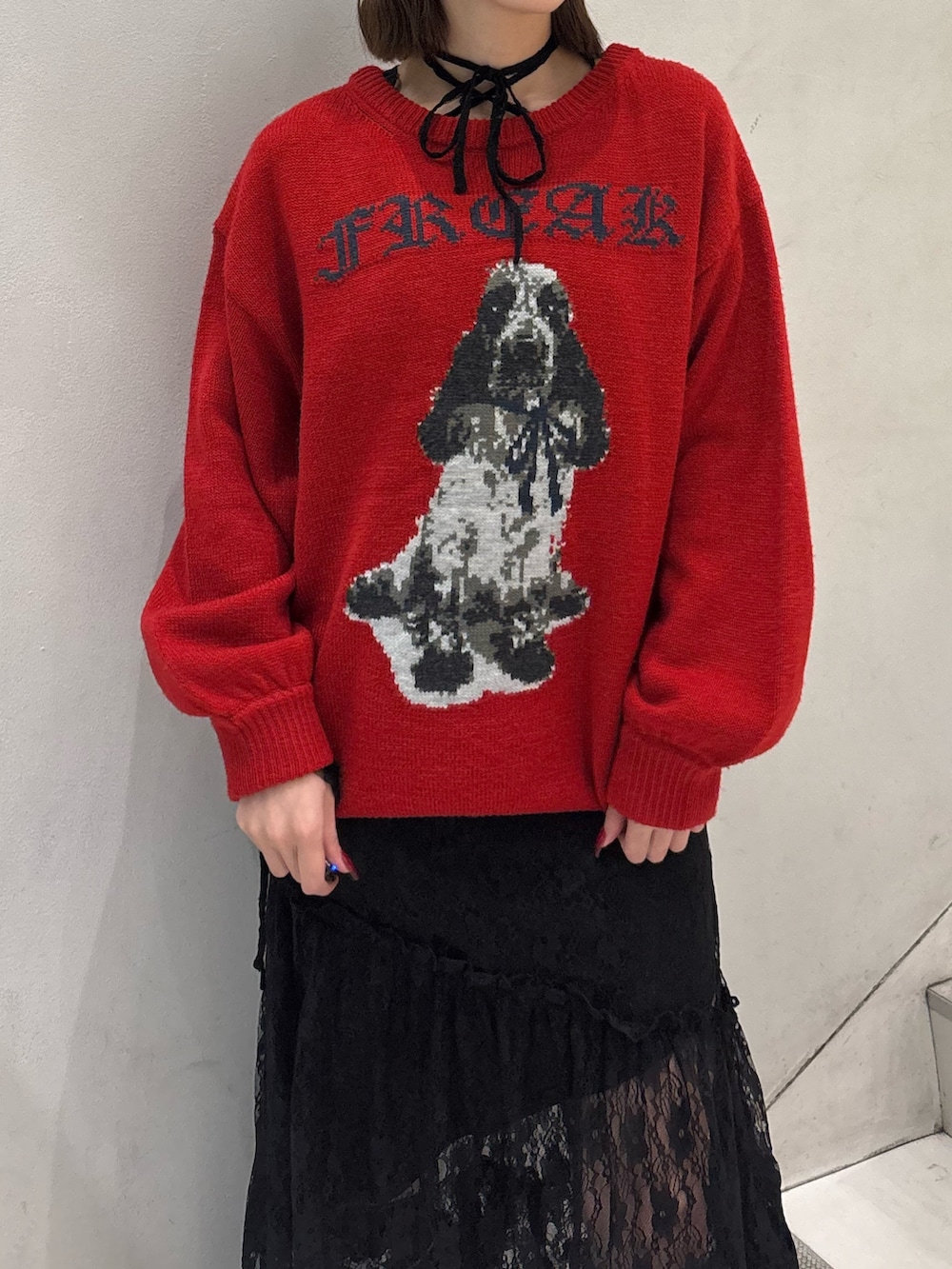 レッド系のニット/セーター、ブラック系のワンピース、ブラック系のブーツを着用したレディースの冬コーディネートの7枚目の写真