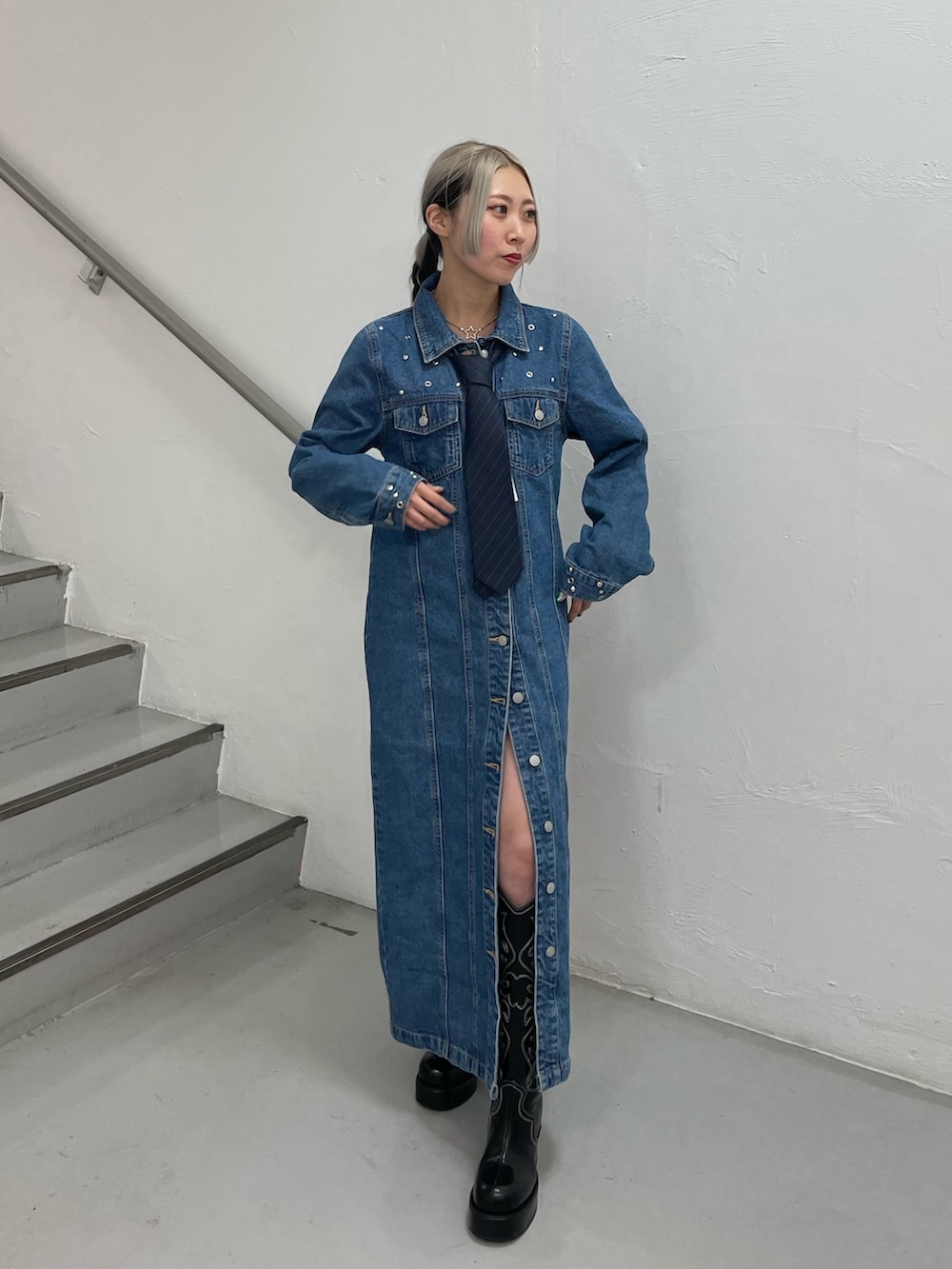 ブルー系のワンピース、ブラック系のブーツ、ブルー系のネクタイを着用したレディースの冬コーディネートの2枚目の写真