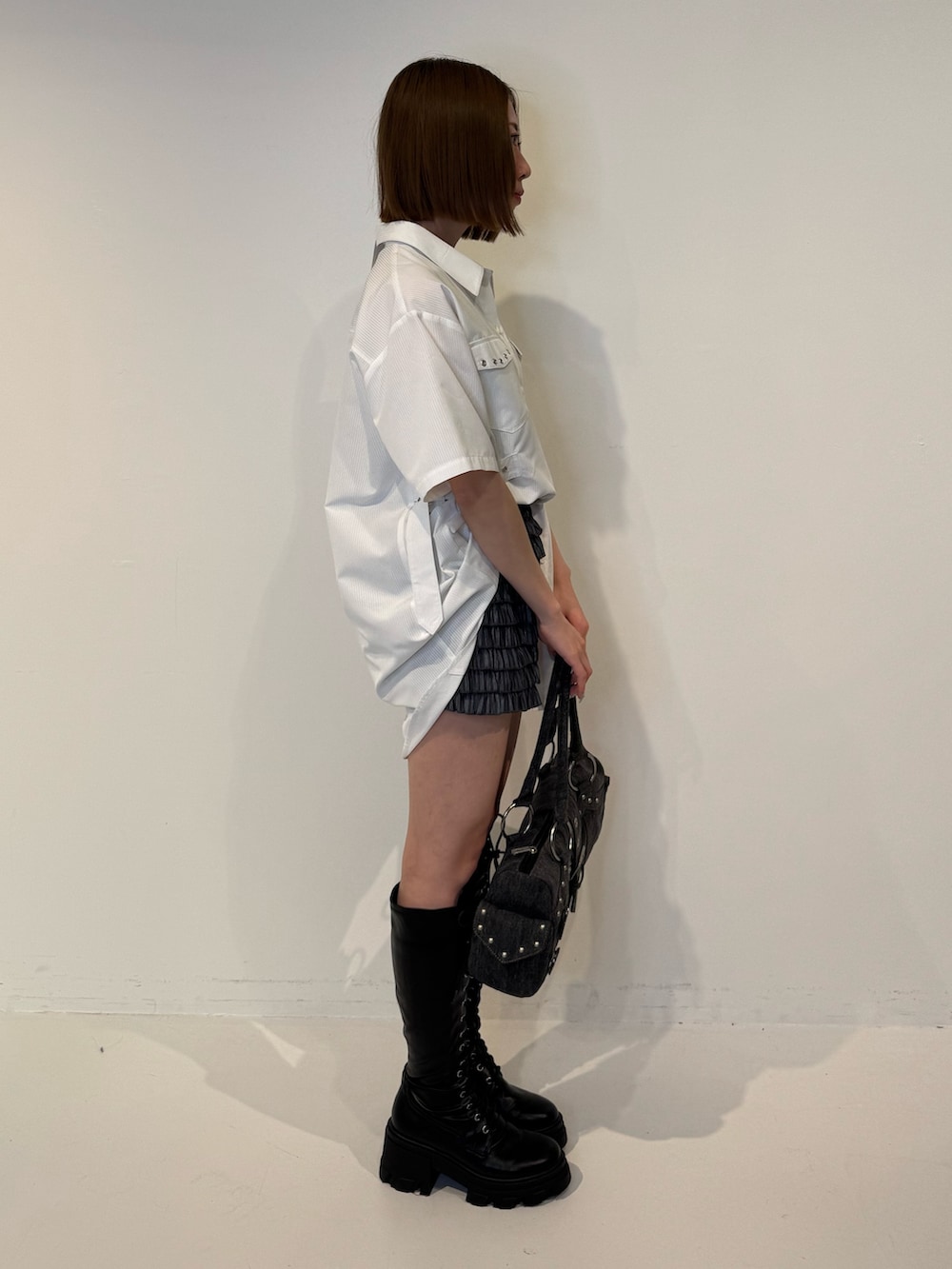 ホワイト系のシャツ/ブラウス、ブラック系のその他パンツ、ブラック系のブーツを着用したレディースの春コーディネートの3枚目の写真