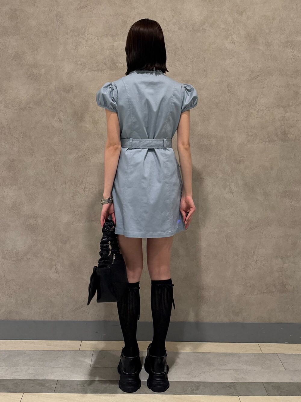 ブルー系のワンピース、ブラック系のハンドバッグ、ブラック系のローファーを着用したレディースの春コーディネートの4枚目の写真