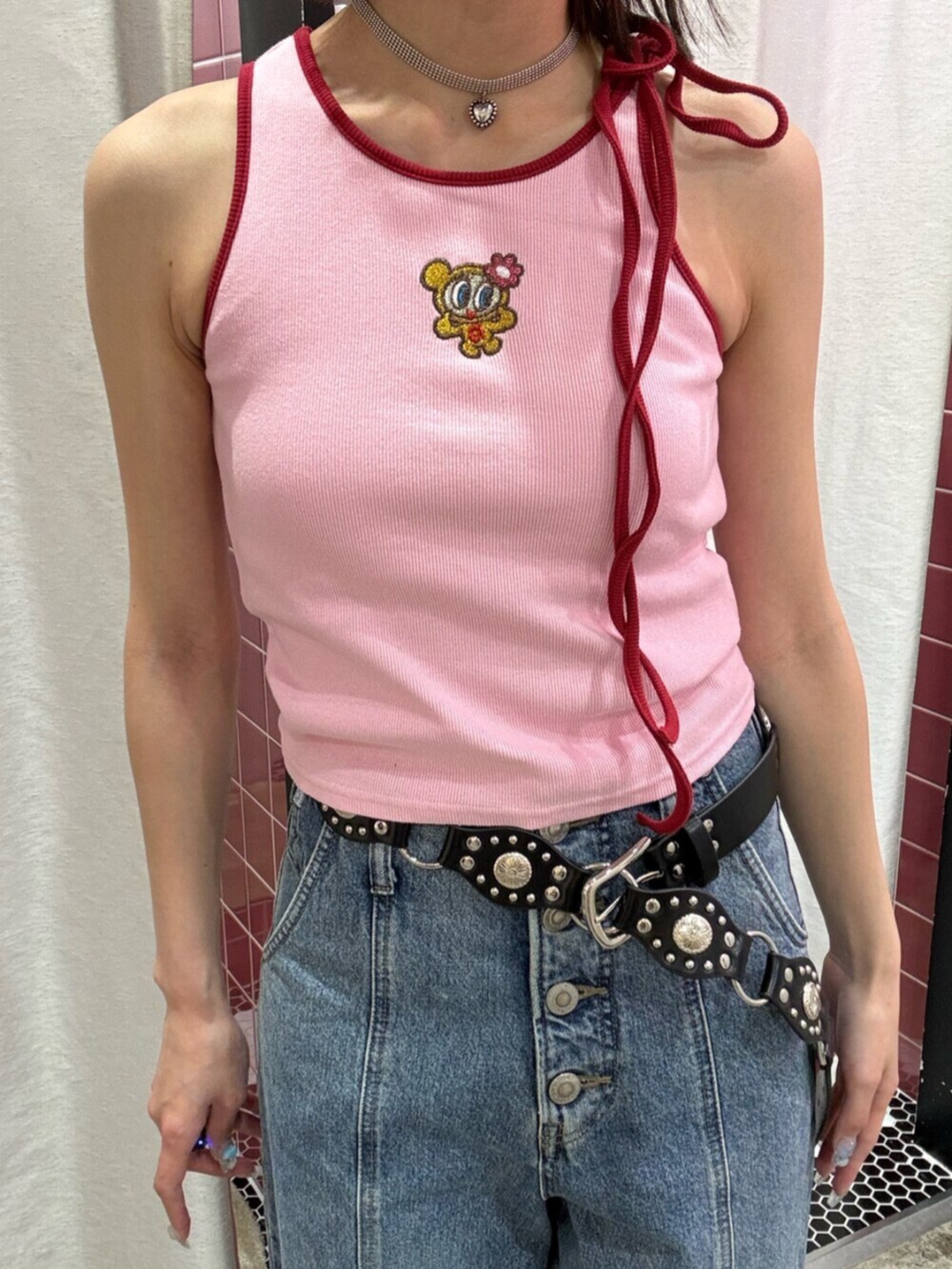 ブルー系のデニムパンツ、ピンク系のキャミソール、ブラック系のパンプスを着用したレディースの夏コーディネートの7枚目の写真
