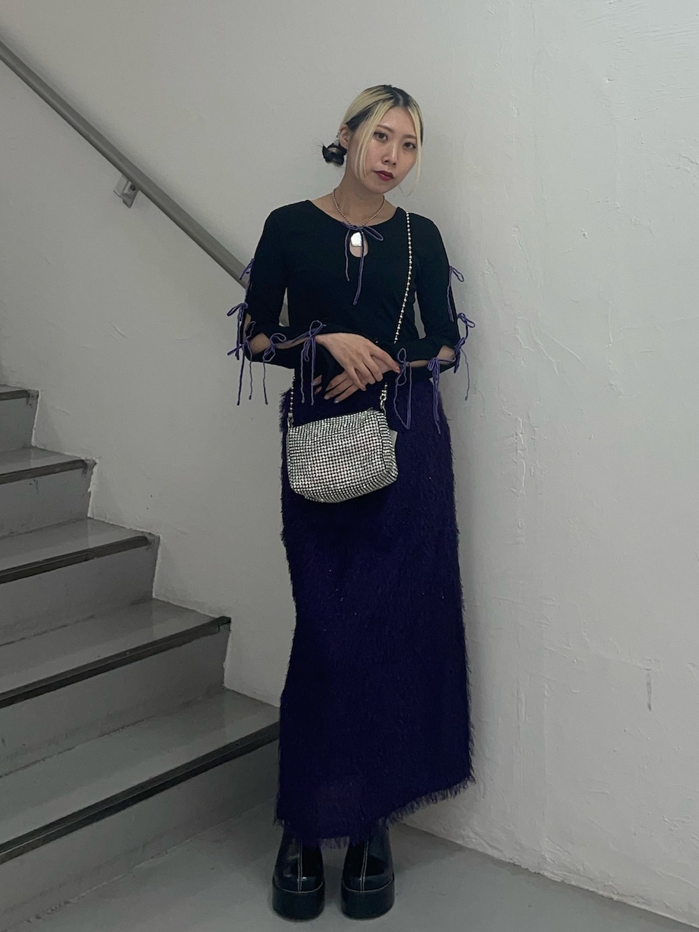 パープル系のスカート、ホワイト系のショルダーバッグ、ブラック系のTシャツ/カットソーを着用したレディースの夏コーディネートの2枚目の写真