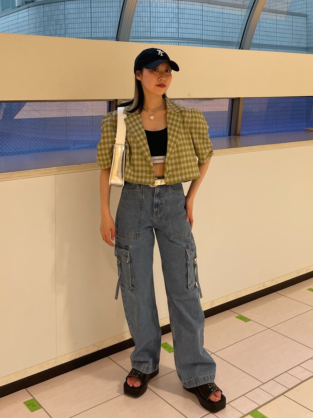 ブルー系のカーゴパンツ、グリーン系のテーラードジャケット、シルバー系のハンドバッグを着用したレディースの春コーディネートの3枚目の写真
