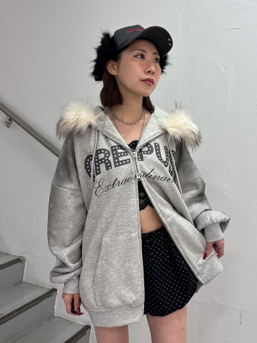 ブラック系のスカート、グレー系のパーカー、ブラック系のブーツを着用したレディースの冬コーディネートの6枚目の写真