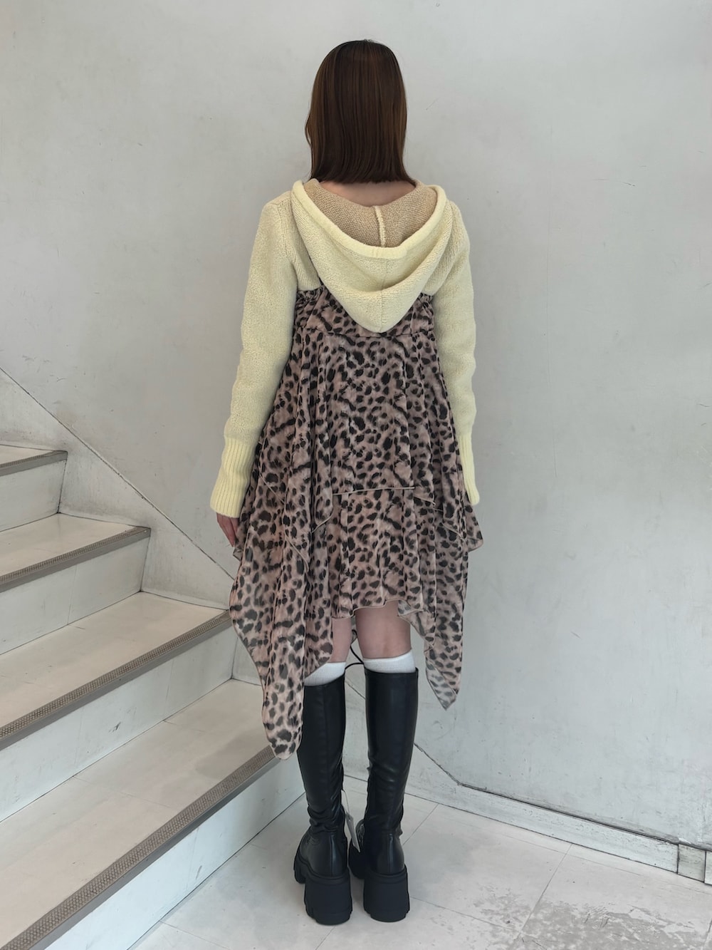 ブラウン系のワンピース、イエロー系のパーカー、ブラック系のブーツを着用したレディースの冬コーディネートの4枚目の写真